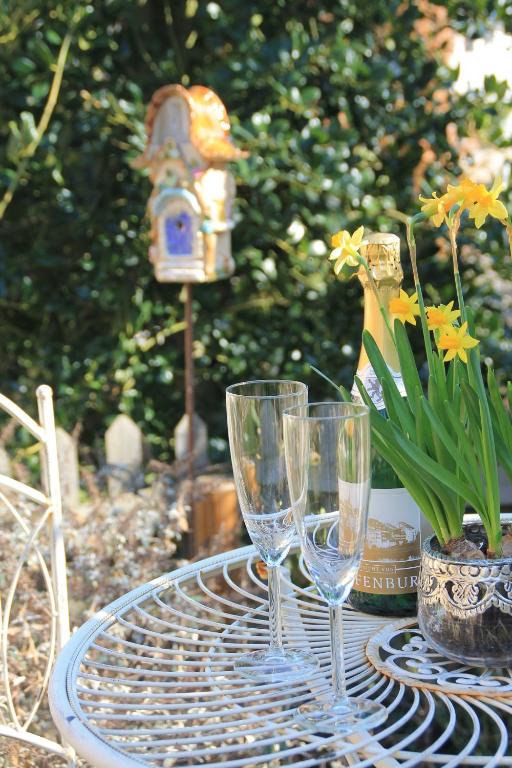 a table with three wine glasses and a bird feeder at Ferienwohnung mit HERZ in Laufenburg in Laufenburg