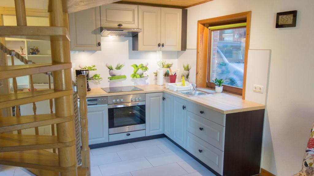 uma cozinha com armários brancos e um lavatório em Ferienhaus Elbtalaue em Bleckede