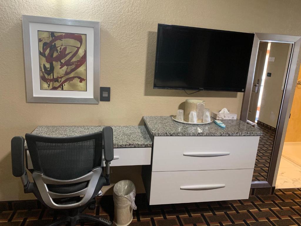 a hotel room with a desk and a chair at Budget Inn Lake Wales in Lake Wales
