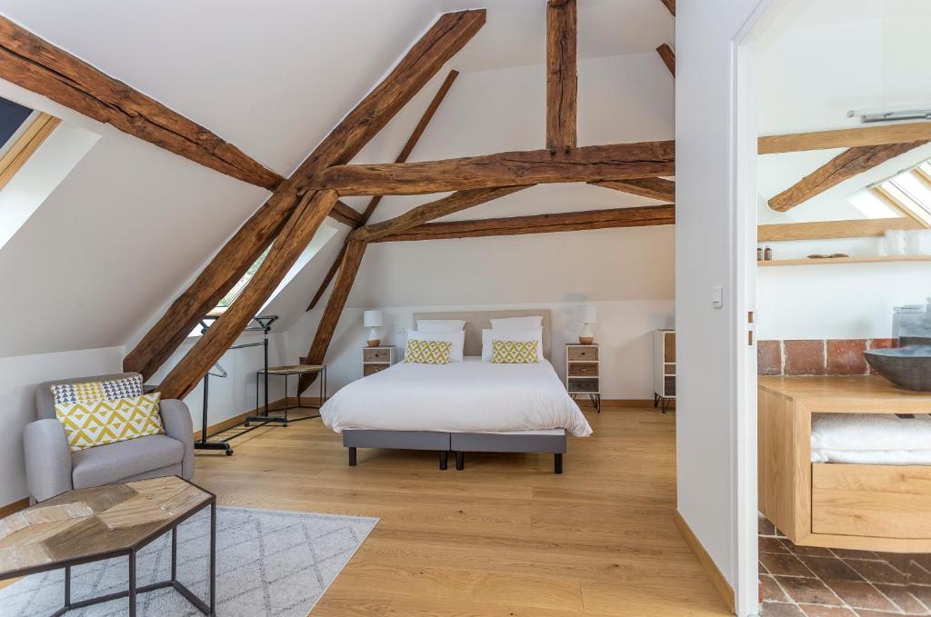 Schlafzimmer mit einem Bett in einem Zimmer mit Holzbalken in der Unterkunft l'Escale de Broglie in Broglie