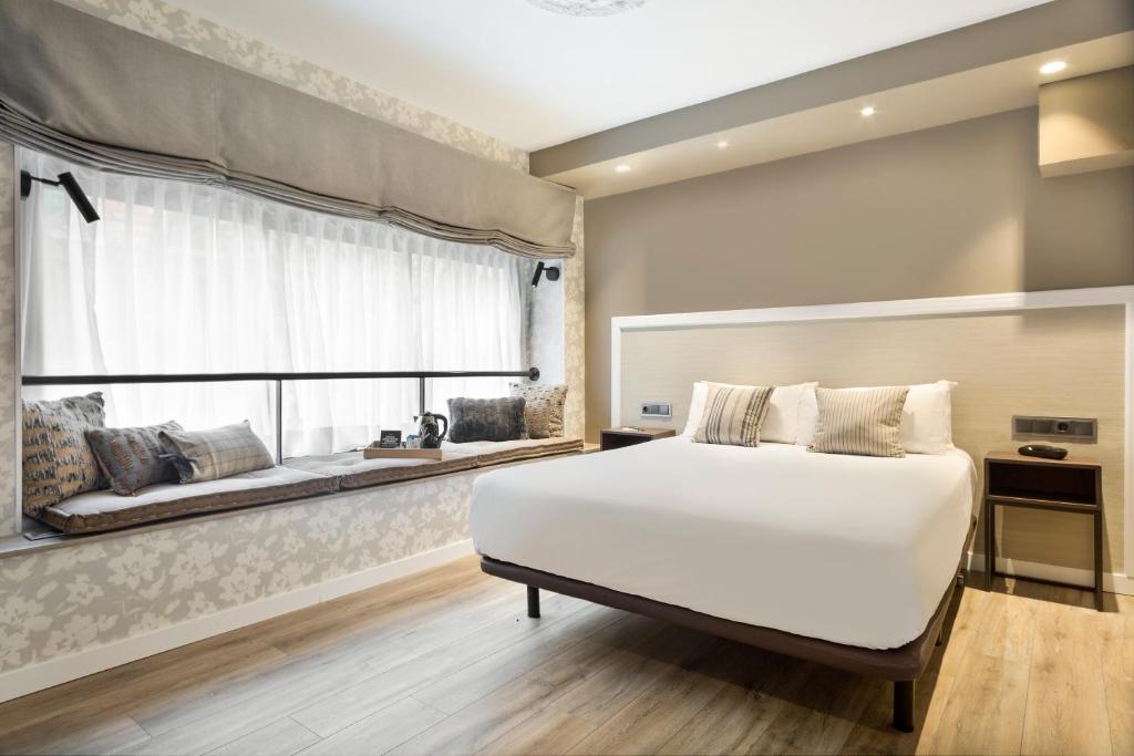 a bedroom with a large white bed and a window at Acta Splendid in Barcelona