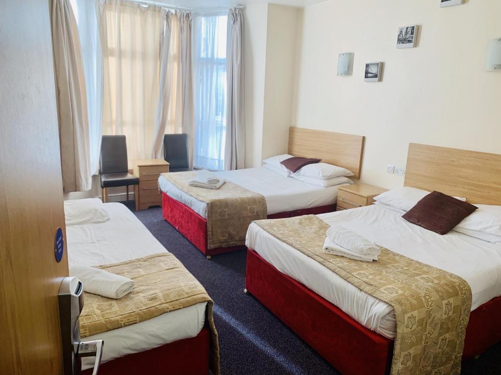 A bed or beds in a room at Britannia Inn Hotel 