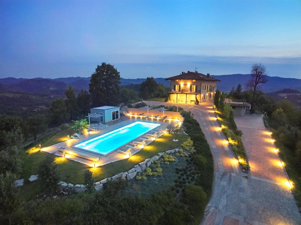 an estate with a swimming pool and a house with lights at La Civignola in Casalborgone
