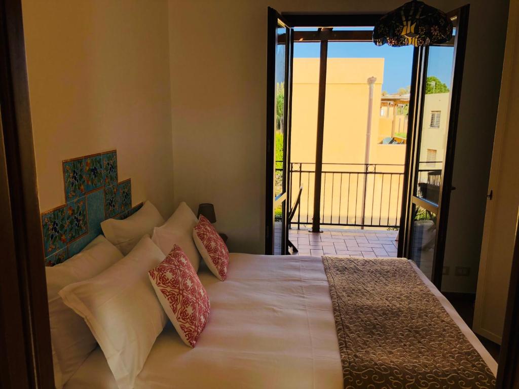 a bedroom with a bed with pillows and a balcony at Appartamento Senia in San Vito lo Capo