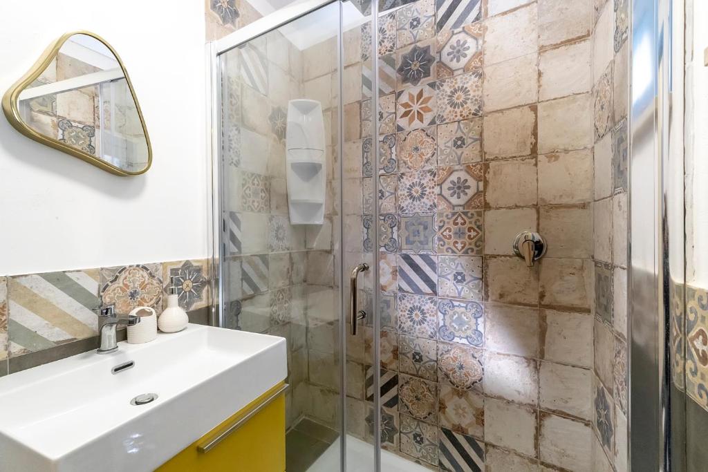 bagno con doccia, lavandino e specchio di Suite&Maré a Favignana