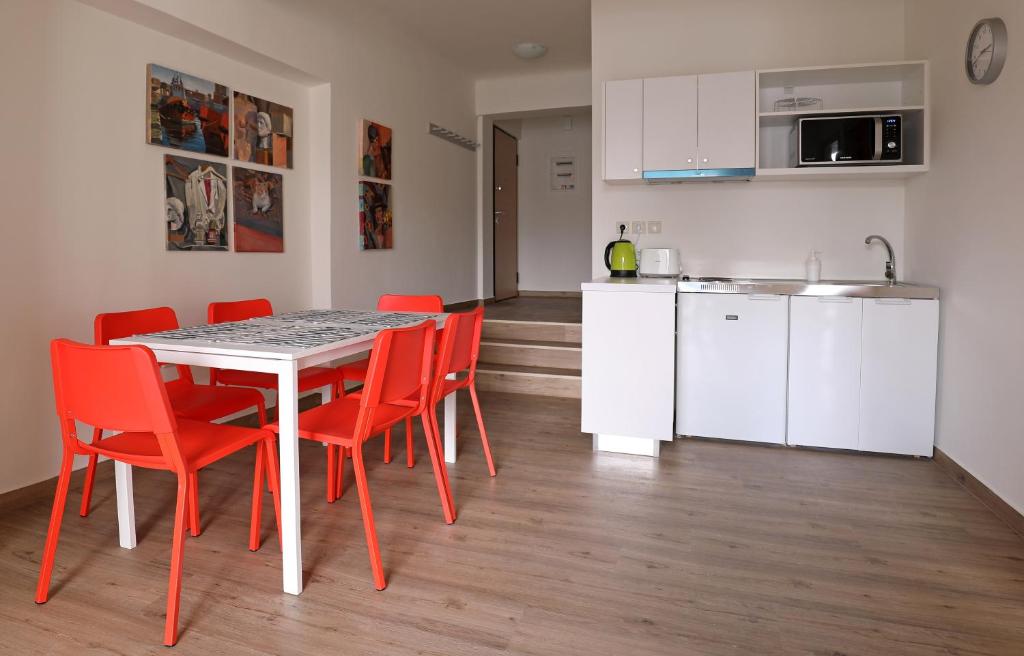 a kitchen and dining room with a table and red chairs at MADONAS HOUSE PSIRI in Athens