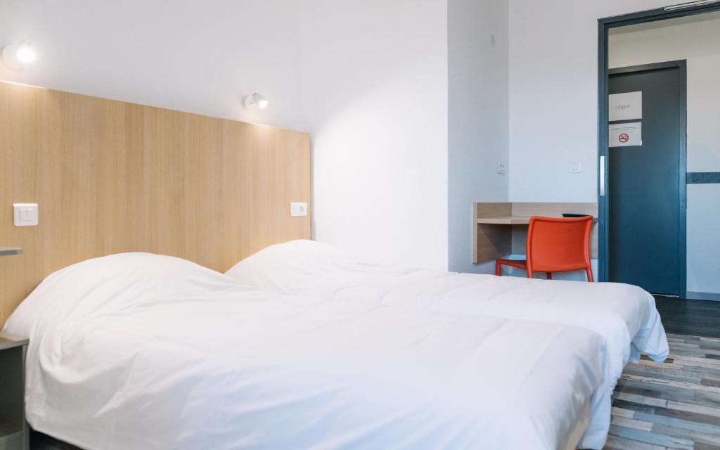 リモージュにあるWelcomotel Limogesのベッドルーム(白い大型ベッド1台、デスク付)