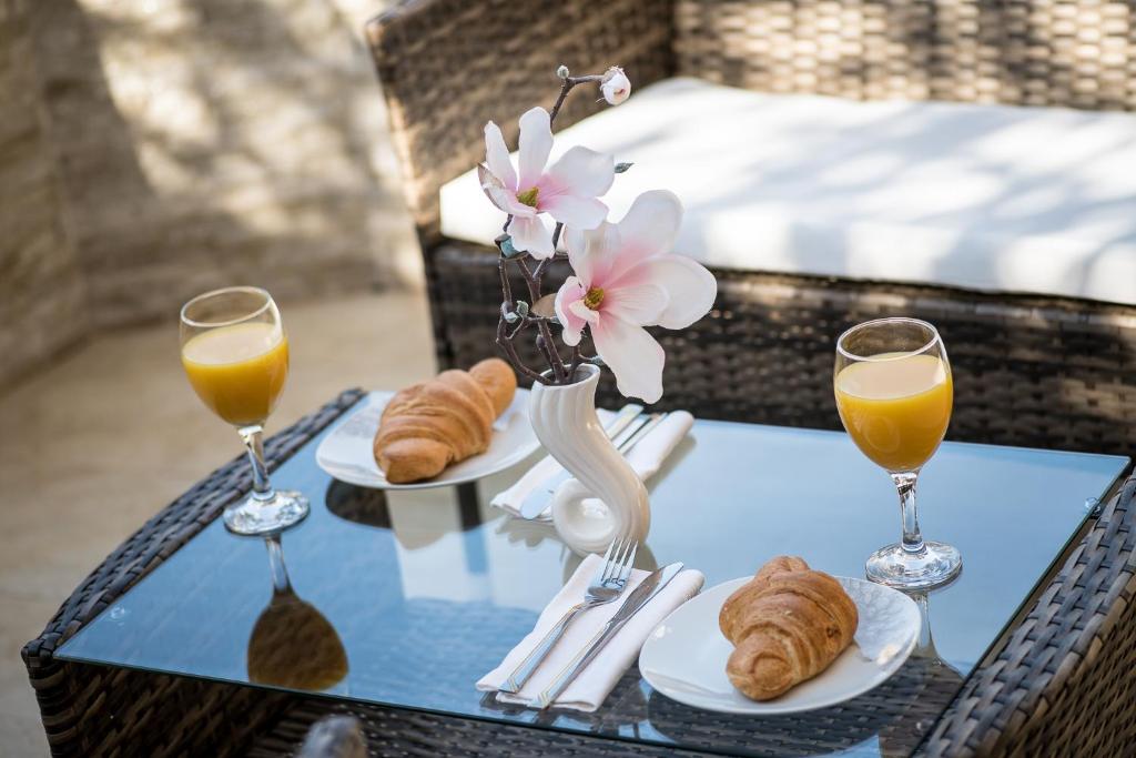 uma mesa com dois copos de sumo de laranja e croissants em S & V Deluxe Apartments em Dubrovnik