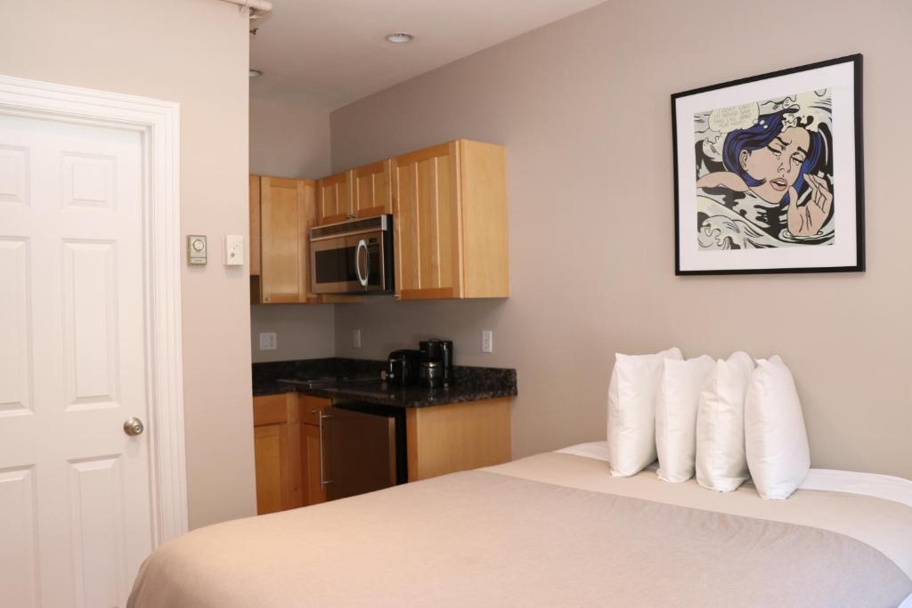 Zimmer mit einem Bett, einer Mikrowelle und einer Küche in der Unterkunft Stylish Downtown Studio in the South End, C. Ave #1 in Boston