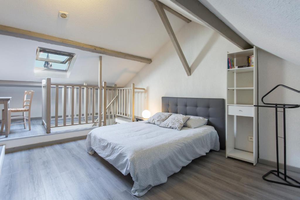 1 dormitorio con 1 cama y escalera en Découvrir Lourdes, en Lourdes