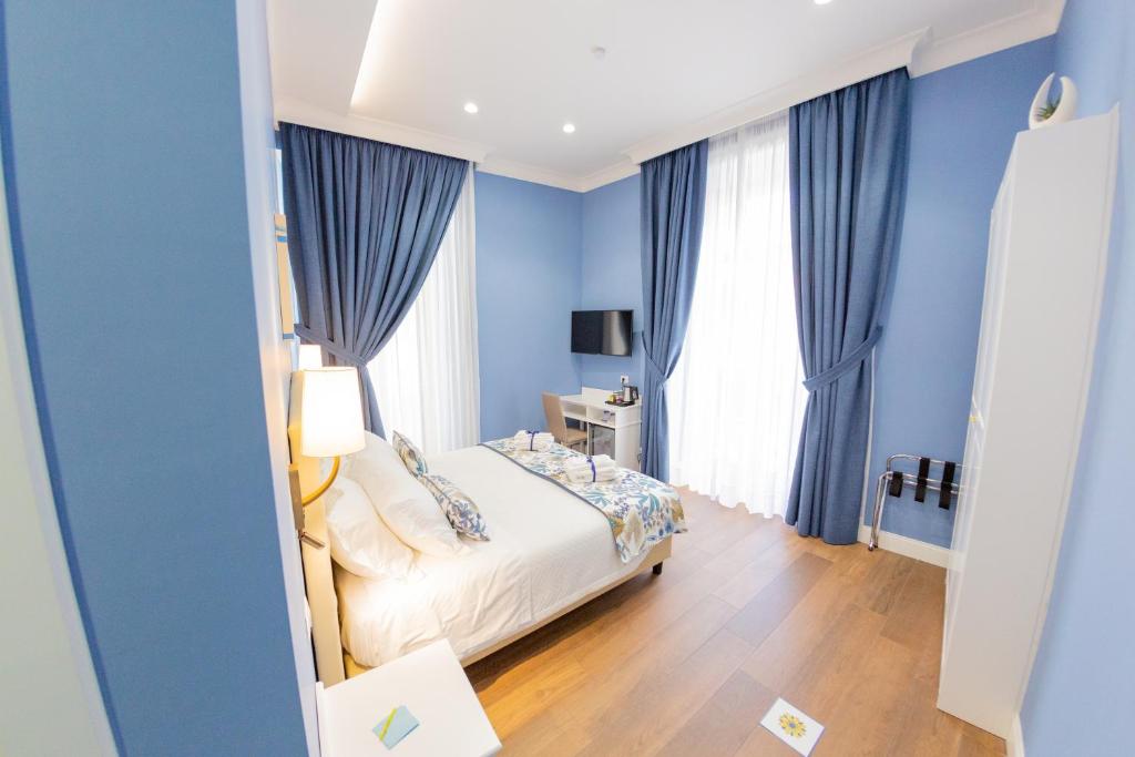um quarto azul com uma cama e cortinas azuis em Suite CuoreNapoletano em Nápoles