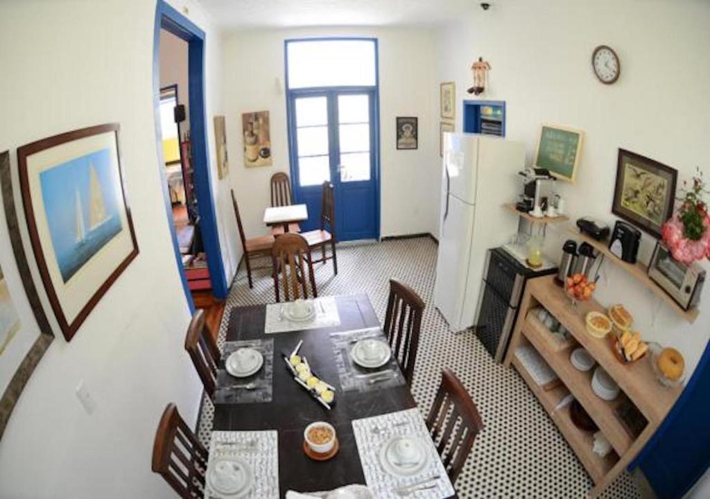 uma sala de jantar com uma mesa e um frigorífico em Brasileranza Hostel em Niterói