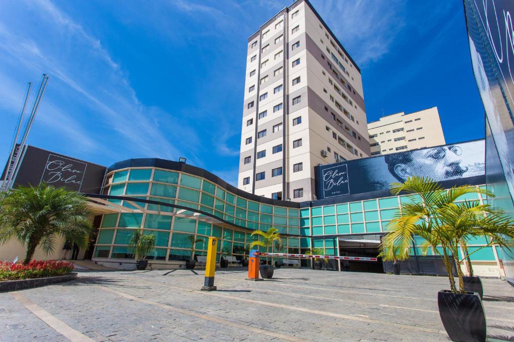 un grand bâtiment avec des palmiers devant lui dans l'établissement Olavo Bilac Hotel, à Taubaté