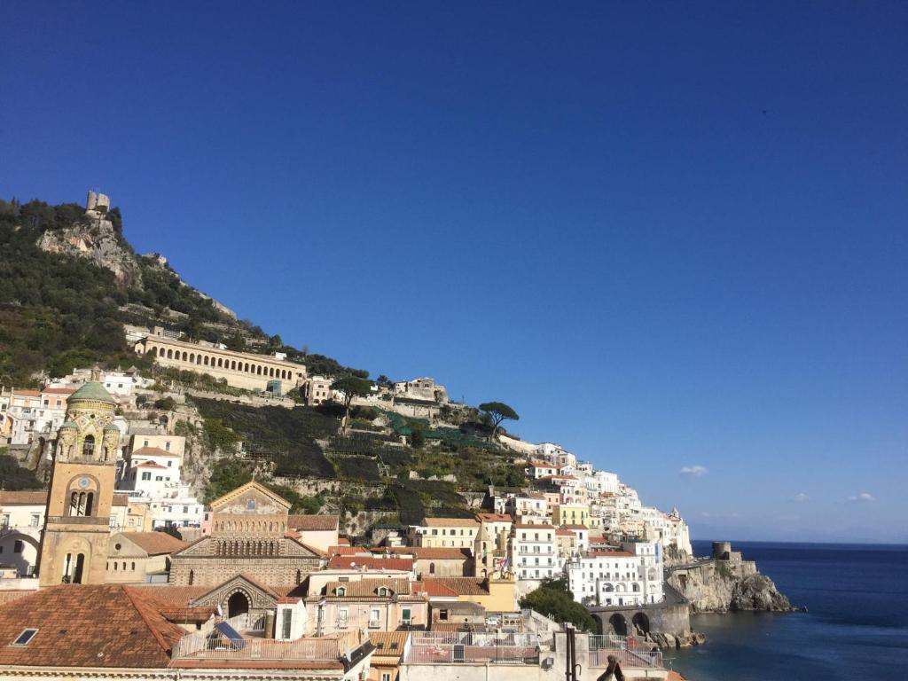 um grupo de edifícios numa colina junto ao oceano em Casa dei Greci em Amalfi