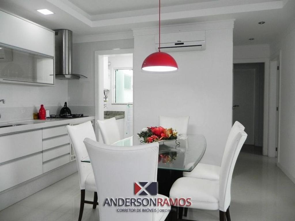 cocina con mesa de cristal y sillas blancas en 1057 - Apartamento para locação em Bombinhas, en Bombinhas