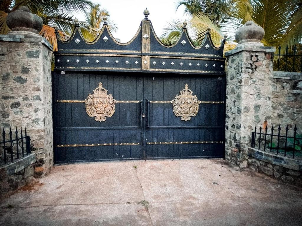 a large blue garage door with a gate at Pearl Crown Homestay in Anuradhapura