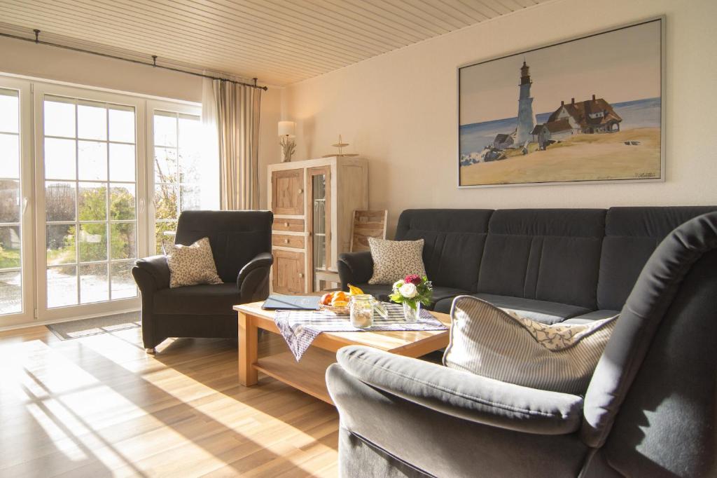 een woonkamer met een bank, stoelen en een tafel bij Haus Daniel in Neuharlingersiel