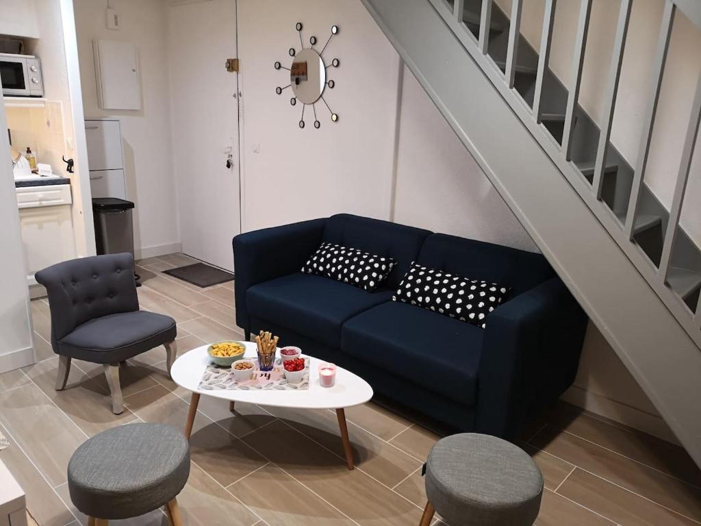 - un salon avec un canapé bleu et une table dans l'établissement Appartement Sainte-Maxime, plage de la Nartelle, à Sainte-Maxime