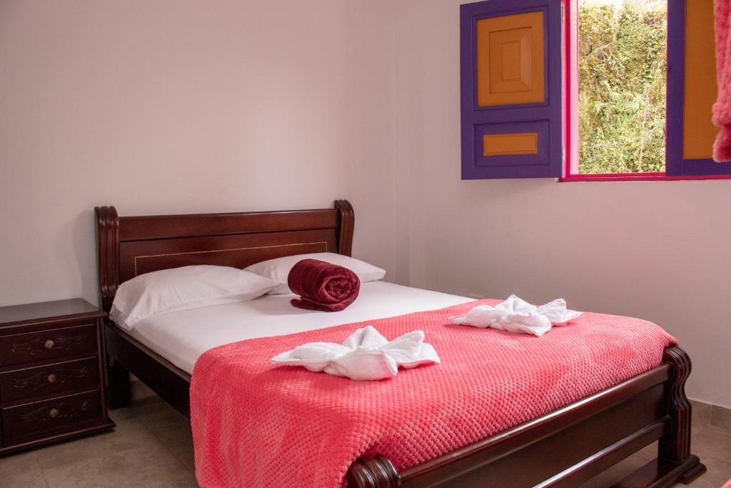 una camera da letto con due asciugamani su un letto di Hostal Palmas De Cocora a Salento