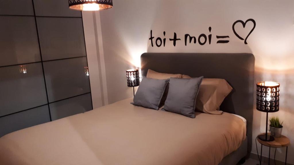 a bed with two lamps and a sign that says hot at La Merveilleuse in Dinant