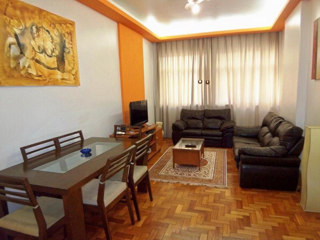 uma sala de estar com uma mesa de jantar e um sofá em Aires 92 no Rio de Janeiro