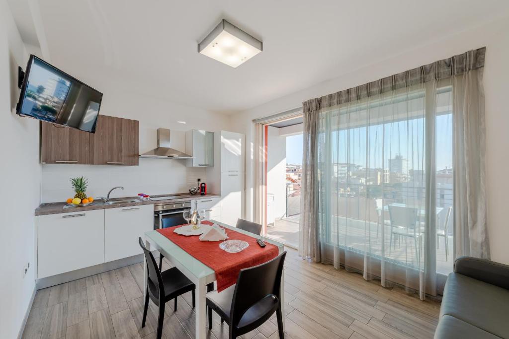 eine Küche und ein Esszimmer mit einem Tisch und Stühlen in der Unterkunft Boca Marina in Alba Adriatica