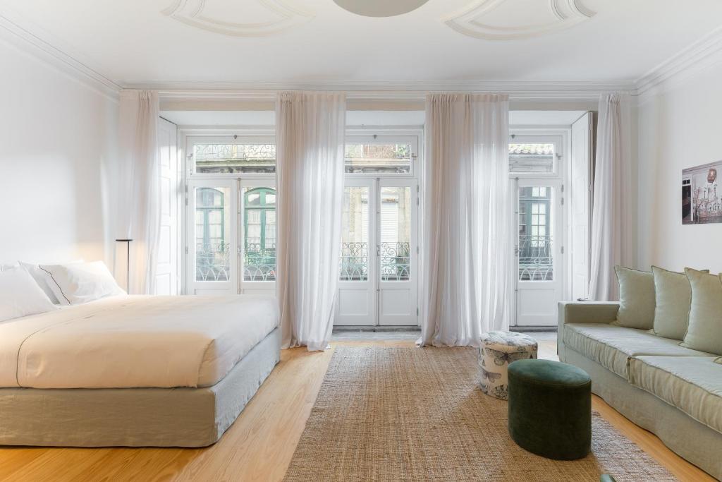 a white bedroom with a bed and a couch at B28 Apartments Porto in Porto