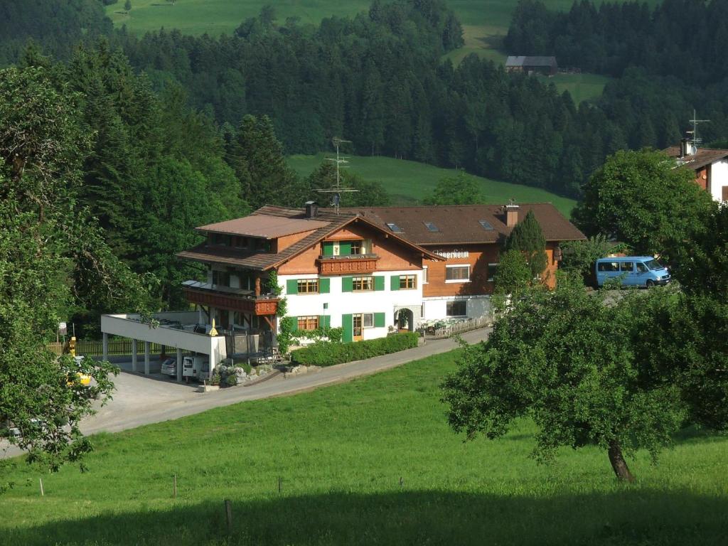 a large house in the middle of a green field at Pension Jägerheim in Krumbach