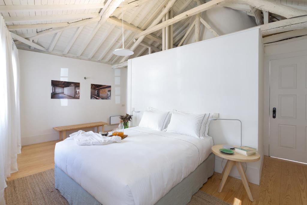 a bedroom with a large white bed and a table at B28 Apartments Porto in Porto