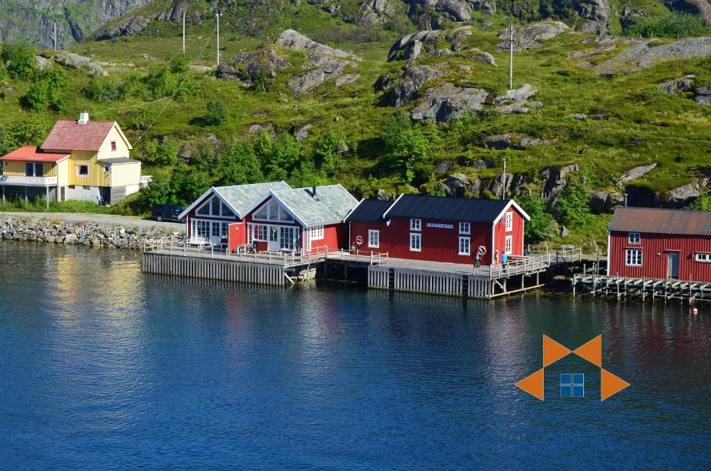 a group of houses on a dock in the water at Lofoten Cabins - Sund in Sund