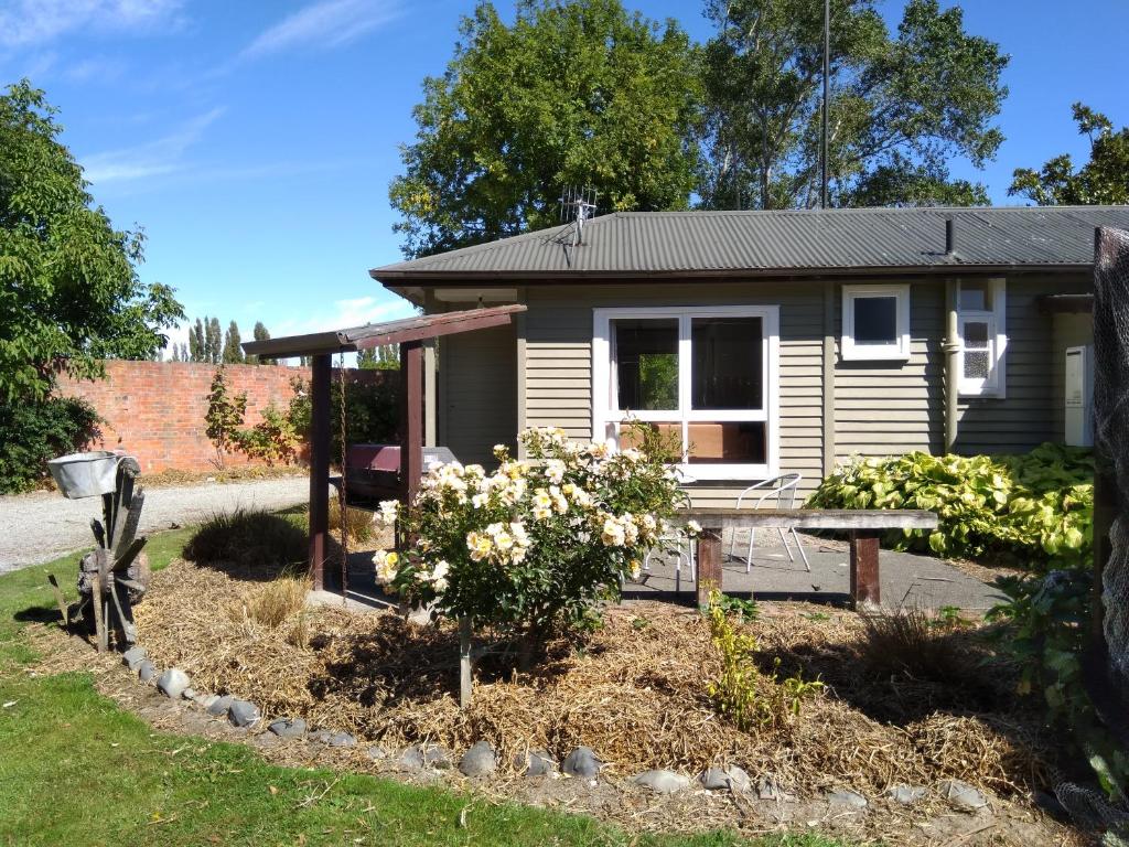 une petite maison avec un jardin en face de celle-ci dans l'établissement Magnolia Cottage B&B, à Pleasant Point