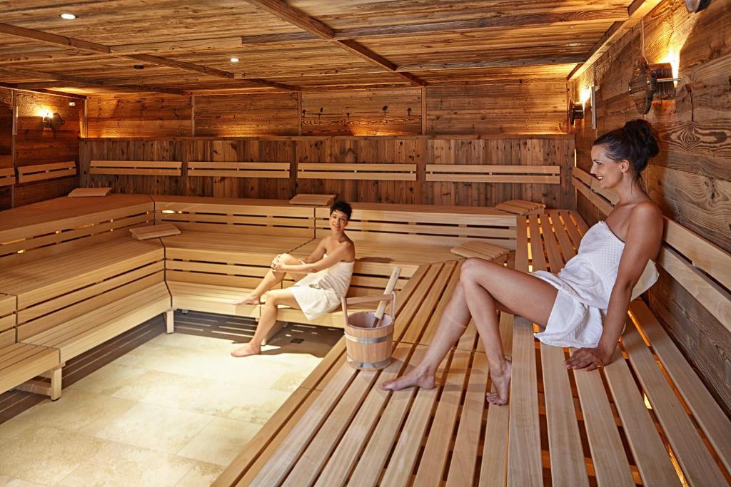 two women are sitting in a sauna at Sporthotel Silvretta Montafon in Gaschurn