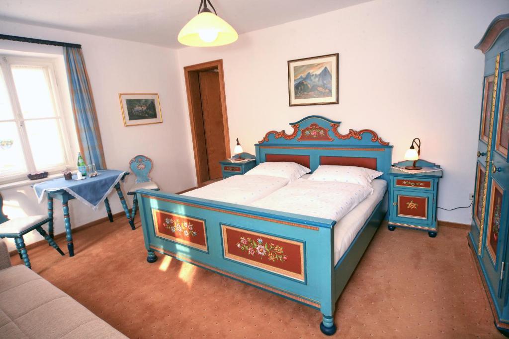 a bedroom with a blue bed and two night stands at Villa Egger in Lofer
