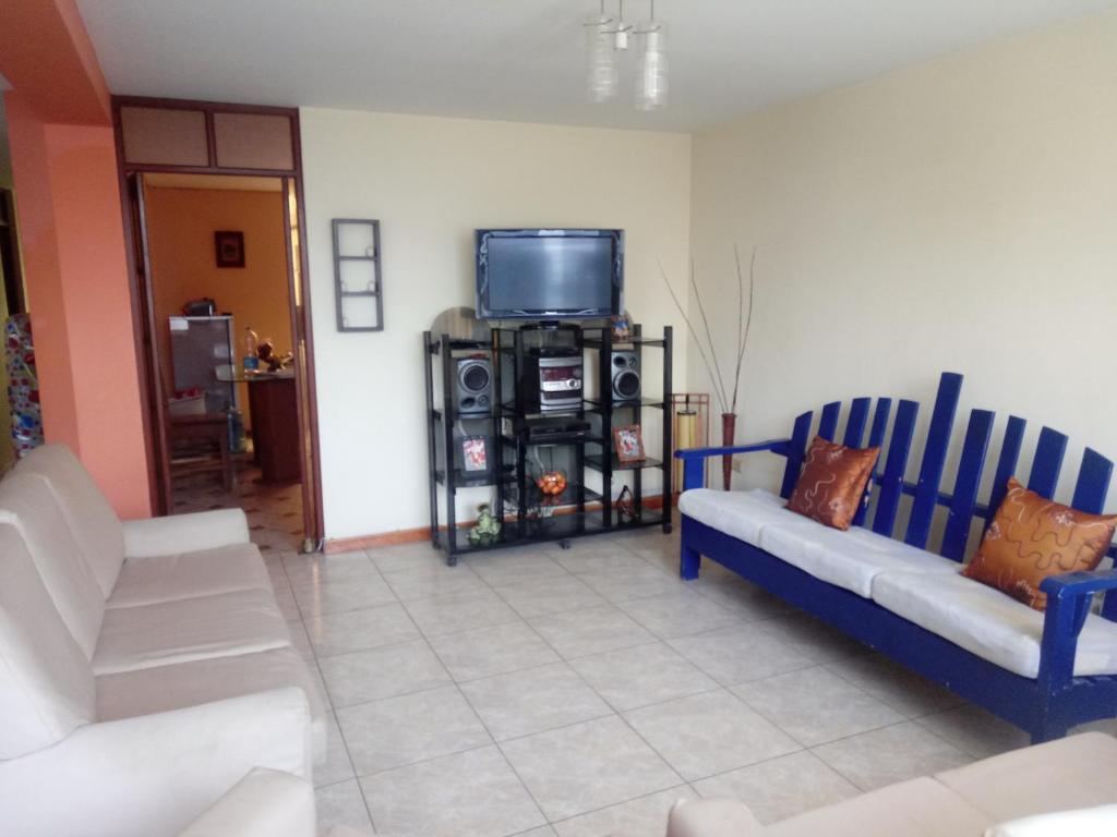 a living room with two blue chairs and a tv at Apartamento Sotillo in Ilo