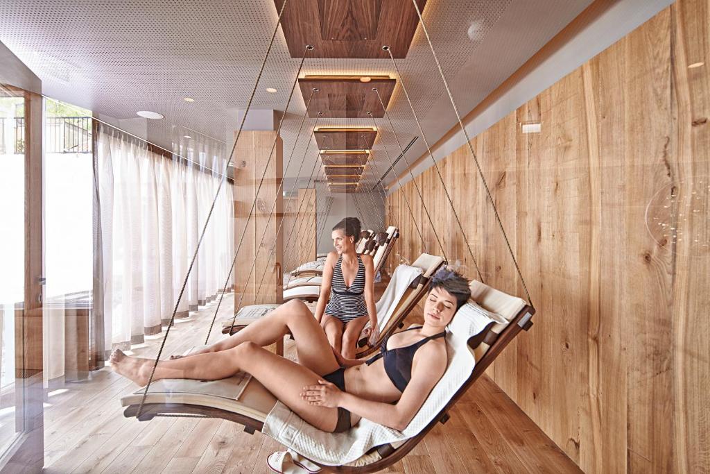 two girls sitting on a swing in a room at Sporthotel Silvretta Montafon in Gaschurn