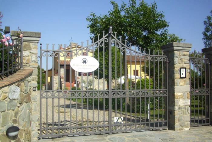 um portão em frente a uma casa com um sinal em B&B Maesta' Di Cudino em Arezzo