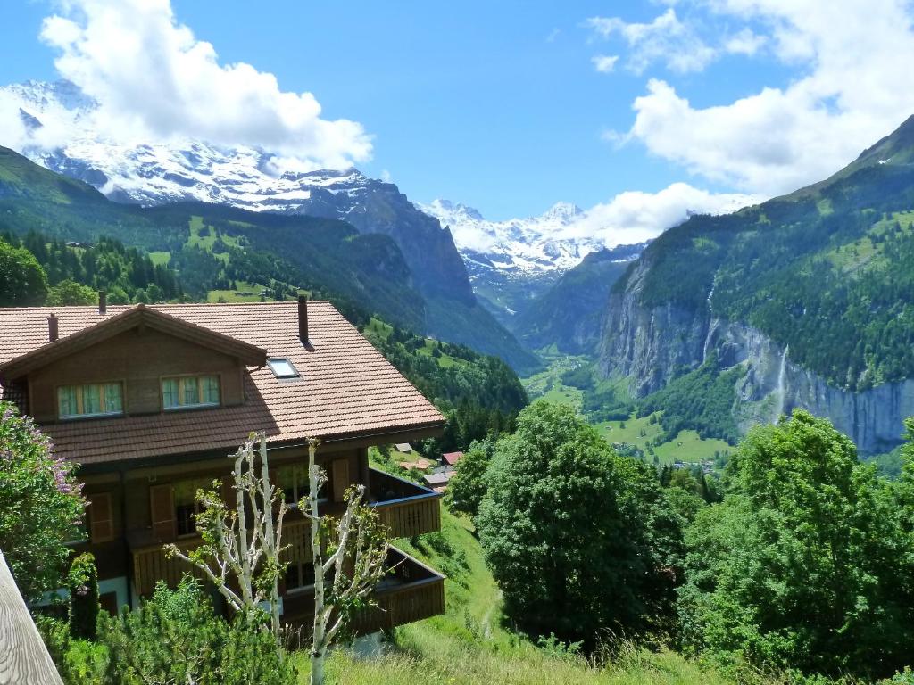 a house in a valley with mountains in the background at Chalet Gerbera in Wengen