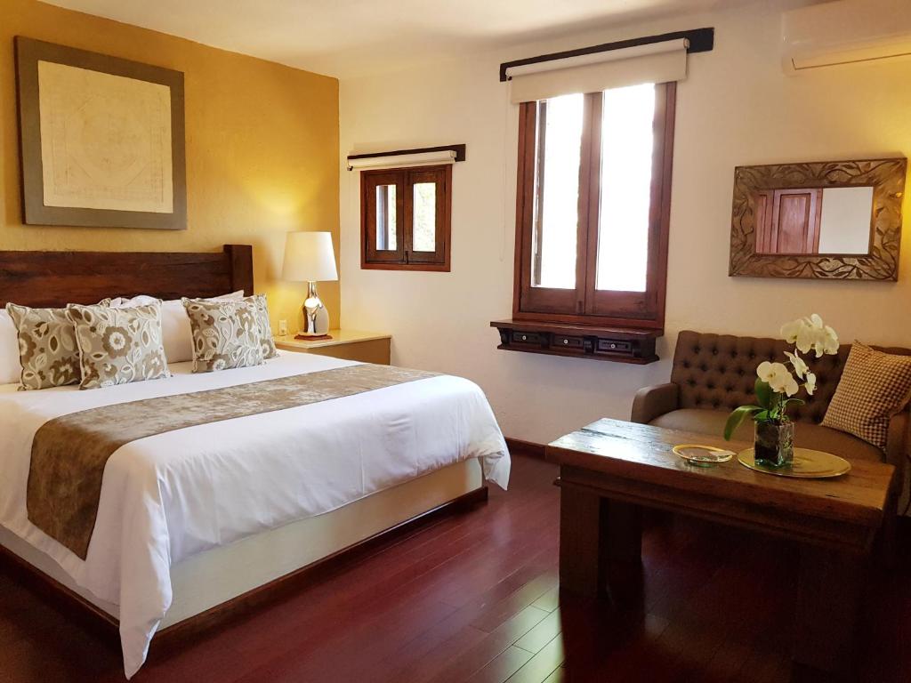 a bedroom with a bed and a table and a chair at Casa Embrujo Morelia - Boutique in Morelia