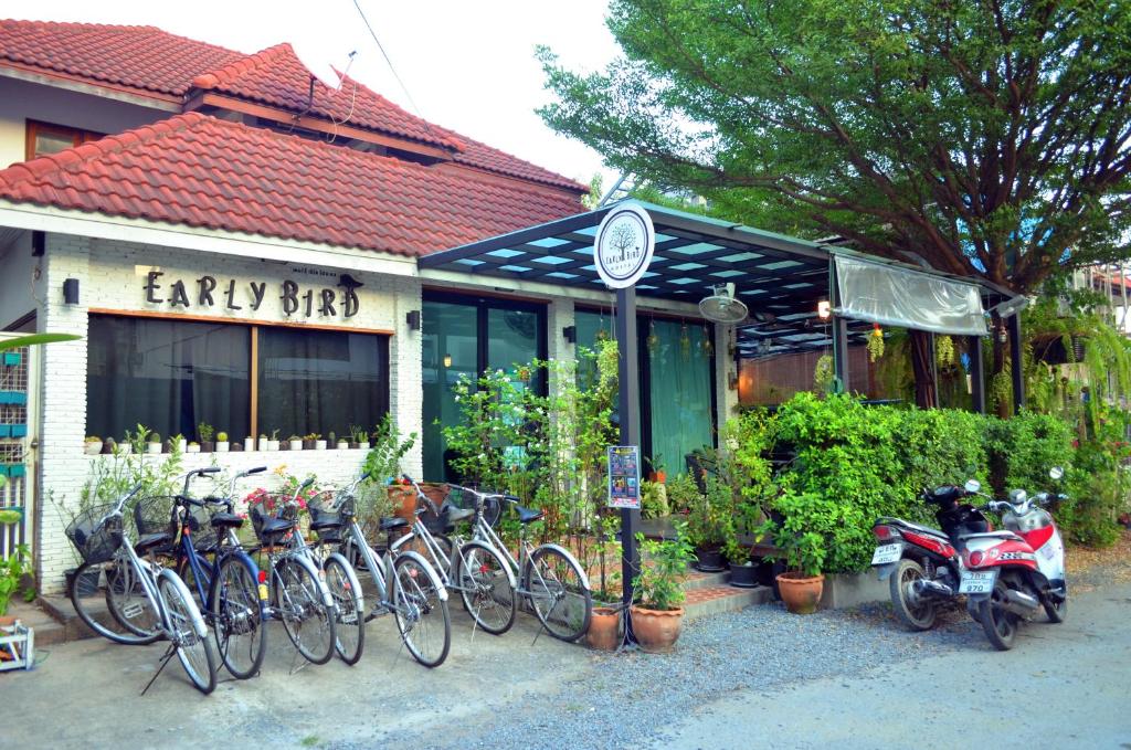 Early Bird Hostel Ayutthaya في فرا ناخون سي أيوتثايا: مجموعة من الدراجات متوقفة أمام المبنى