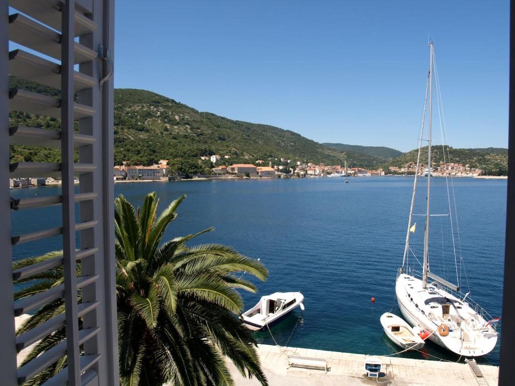 dois barcos estão ancorados numa grande massa de água em Villa Riva, Vis em Vis