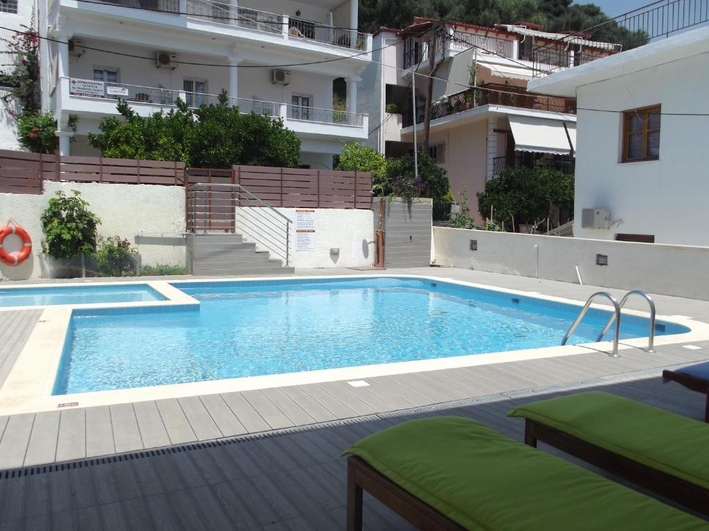 a pool with a chair and a pool table in it at Christina Studios & Apartments in Parga