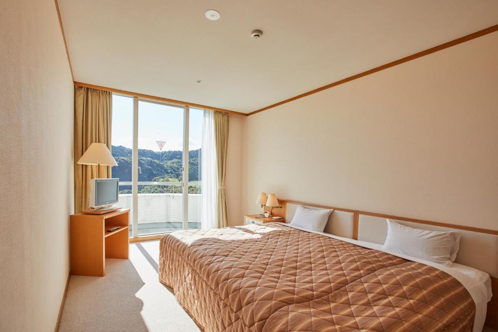 Postel nebo postele na pokoji v ubytování Kamogawa Country Hotel
