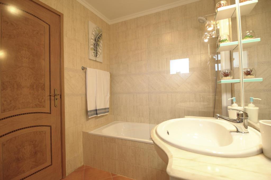 a bathroom with a sink and a bath tub at Condominio do Mar in Lagos