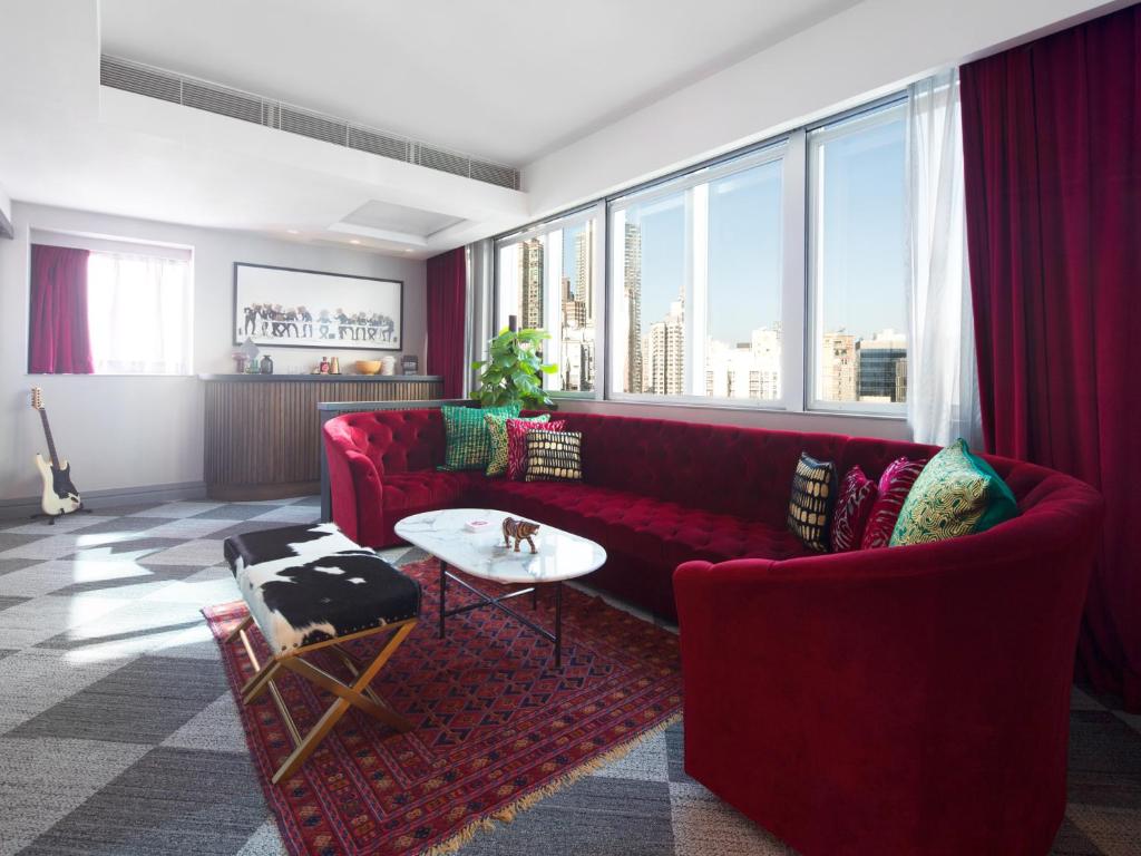 a living room with a red couch and a table at Ovolo Central in Hong Kong