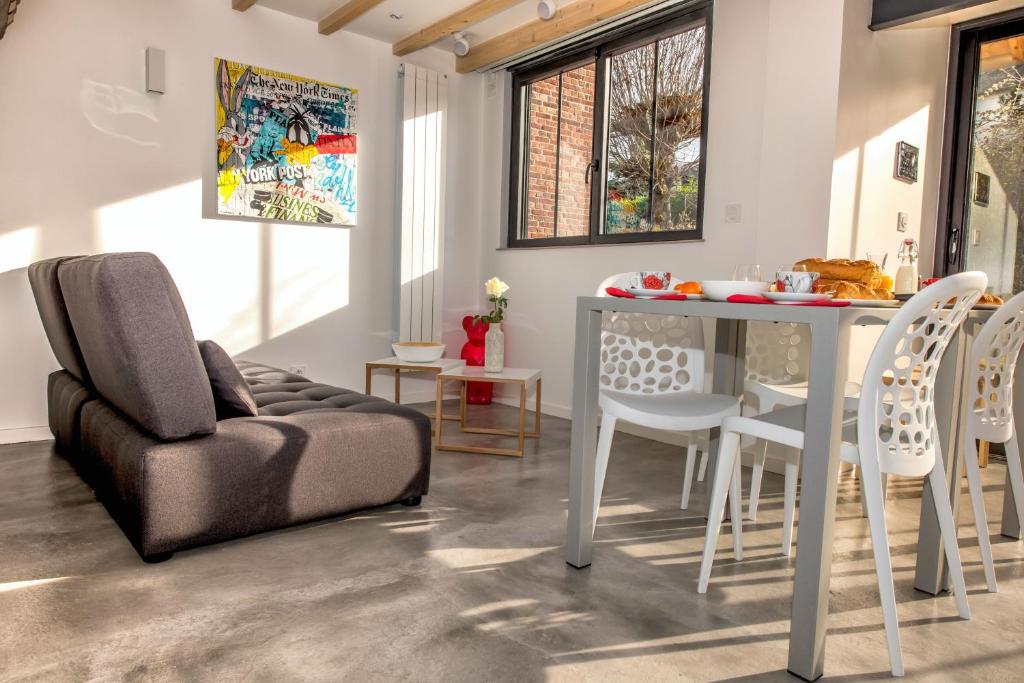 a living room with a couch and a table and chairs at The Tiny House in Honfleur