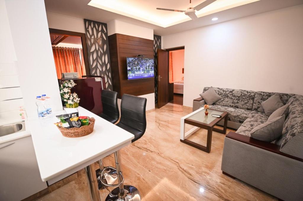 ein Wohnzimmer mit einem Sofa und einem Tisch in der Unterkunft Chola Serviced Apartment in Tiruchchirāppalli