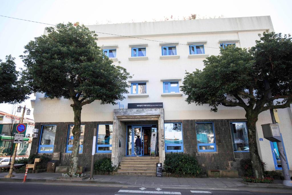 a man standing in the doorway of a building at Olle Stay in Seogwipo