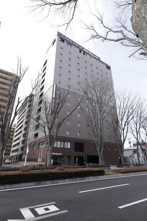 un grand bâtiment sur le côté d'une rue dans l'établissement Dormy Inn Maebashi, à Maebashi