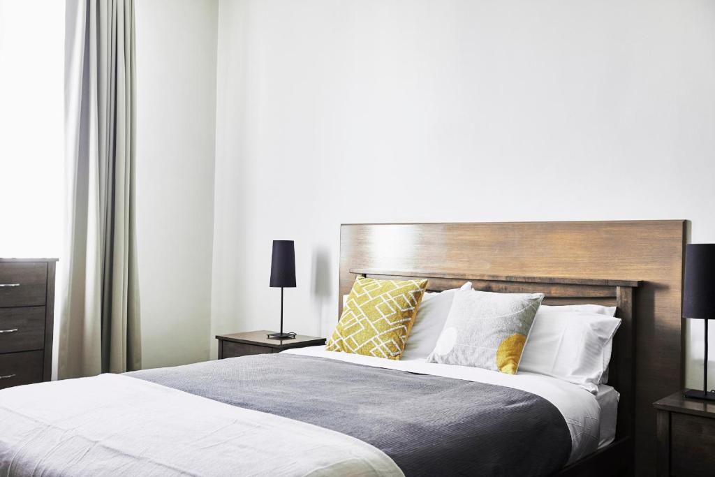 a bedroom with a large bed with a wooden headboard at Plough Hotel in Melbourne