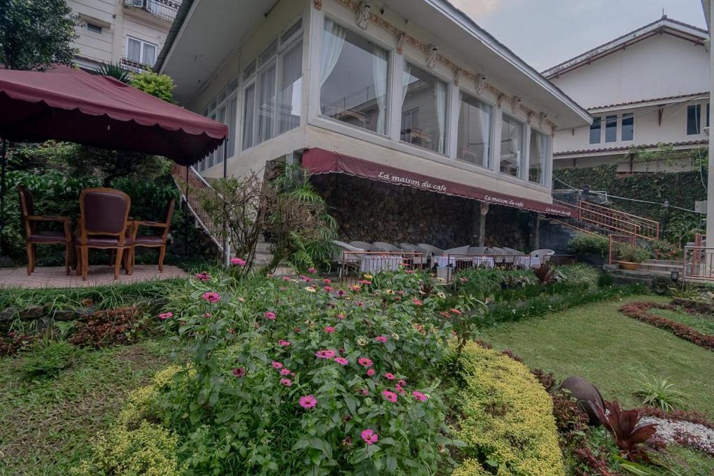 una casa con patio arredato con sedie e fiori di Urbanview Hotel Mon Bel Cibodas a Gegarbensang